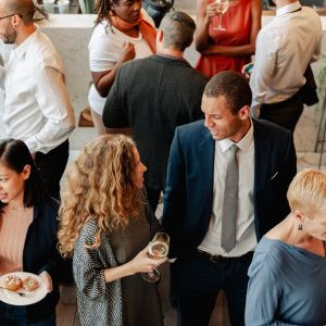Eine Gruppe Menschen bei einer Kitchen Party im Gespräch vertieft