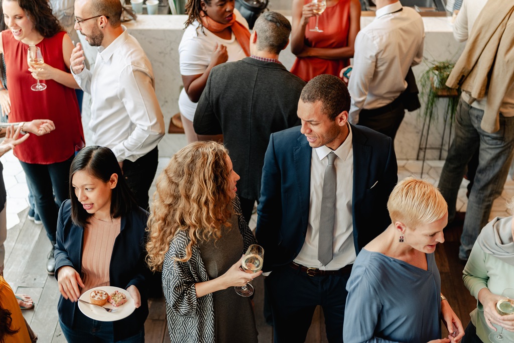 Eine Gruppe Menschen bei einer Kitchen Party im Gespräch vertieft